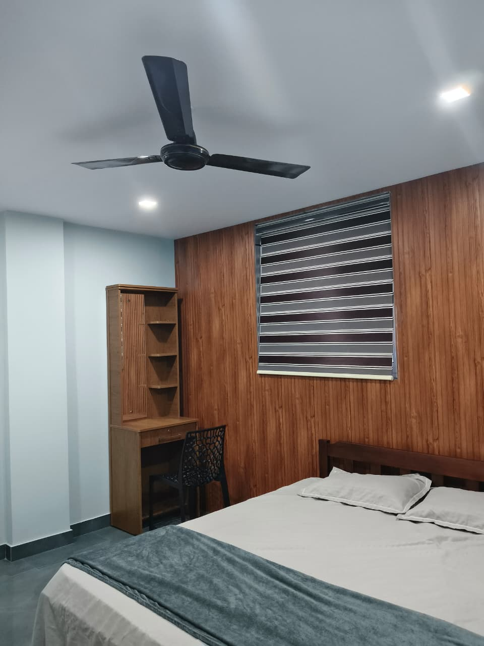 Guest room with a double bed and wooden feature wall
