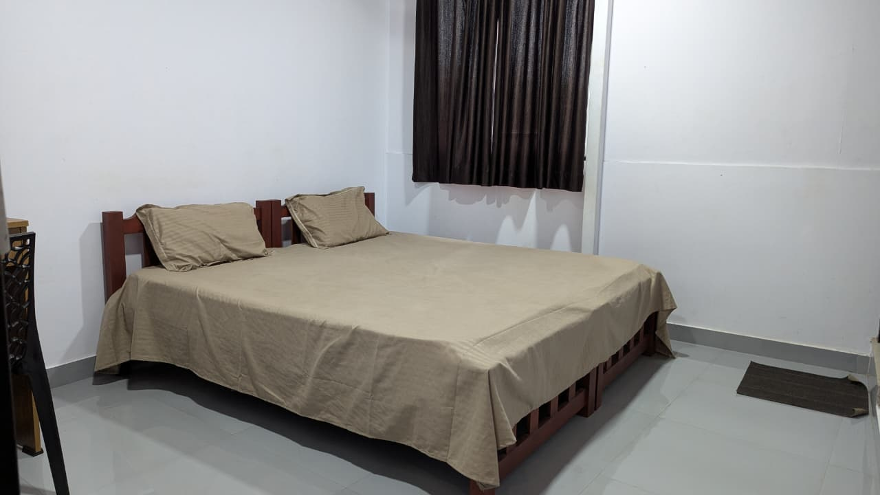 Guest room with a double bed and curtains